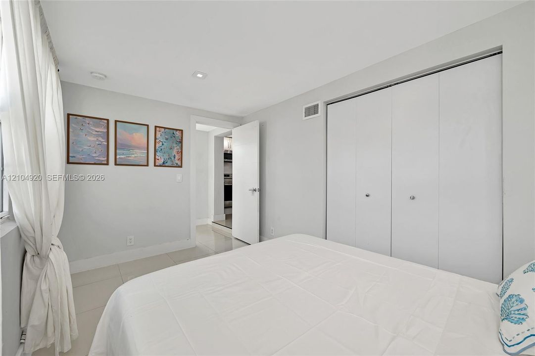 Interior room featuring large-format tile flooring, recessed lighting, and a double-door closet with polished hardware