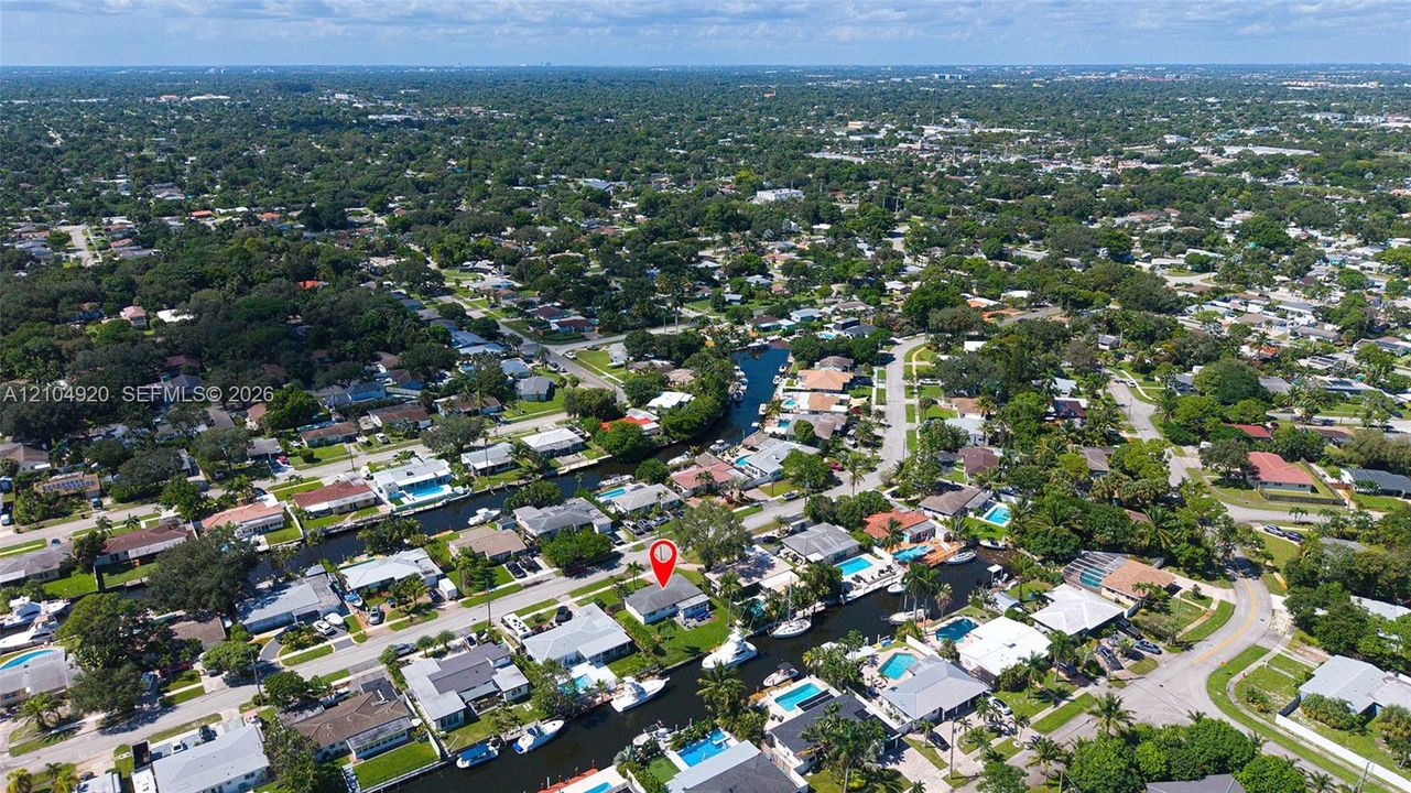 Aerial perspective of the waterfront property featuring direct canal access and residential street positioning