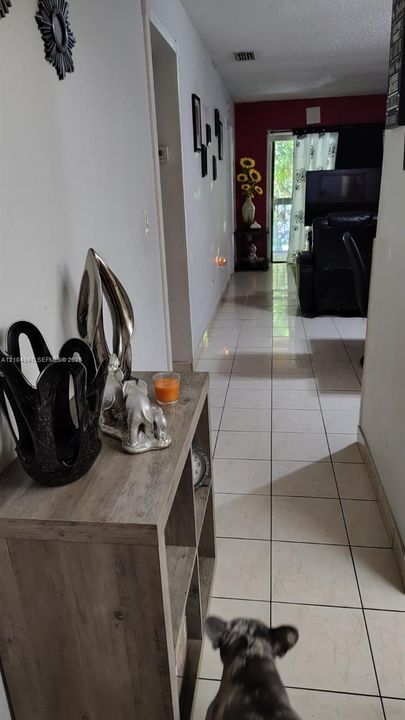 Interior hallway featuring light-toned ceramic tile flooring and neutral wall finishes