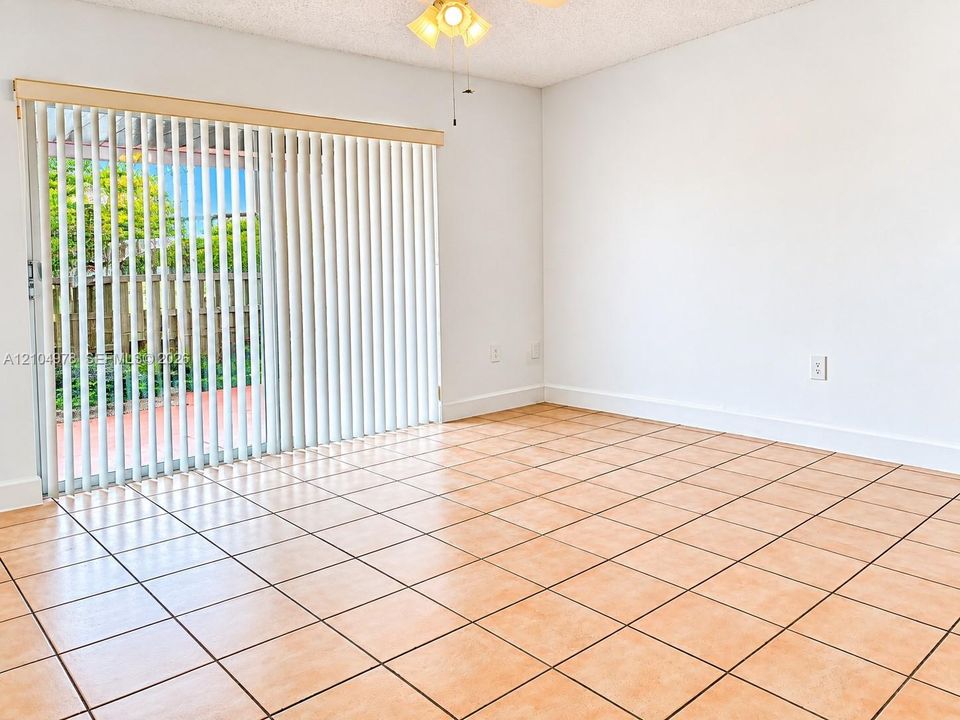 sliding glass door, vertical blinds, and ceiling fan