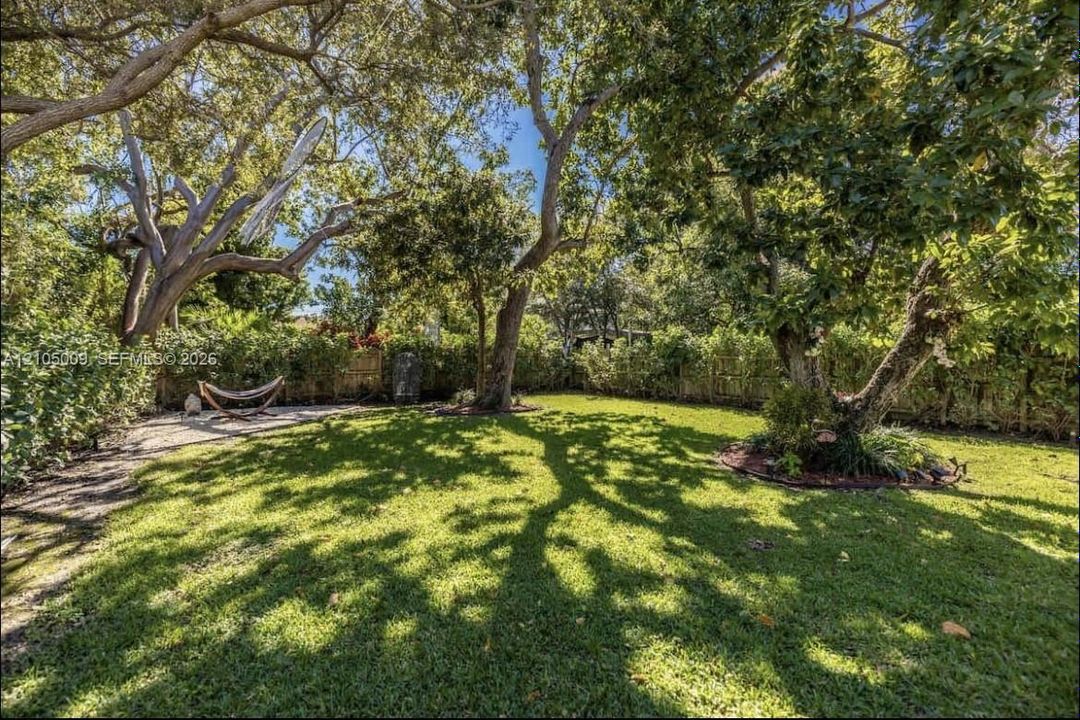 Expansive lawn featuring mature trees and established landscaping