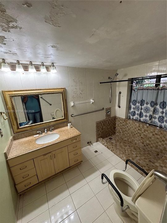 Vanity with a single basin sink, granite countertop, and wood-finish cabinetry