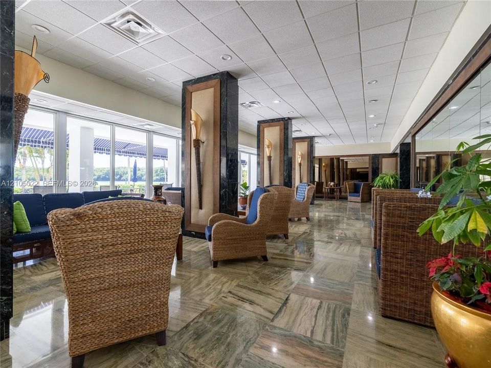 Polished stone flooring with natural variations, floor-to-ceiling windows, and recessed lighting