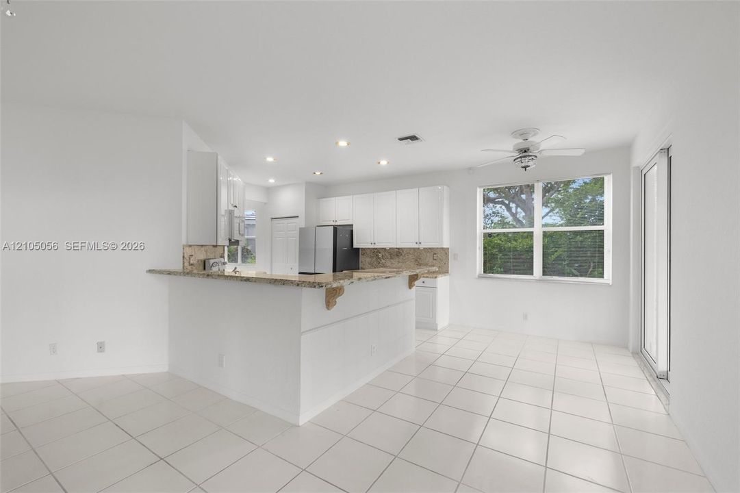 Kitchen featuring large breakfast snack counter and casual eat-in sitting area.