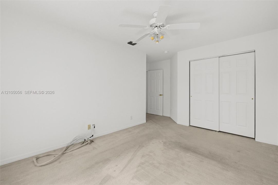 2nd Bedroom view to entry way and a closet with sliding paneled doors