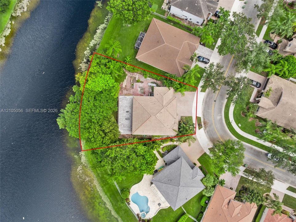 Aerial perspective of a this waterfront property featuring a double sized lot with a massive 139 ft of water frontage - this is a rarely available opportunity to acquire the best waterfront lot location at Emerald Estates