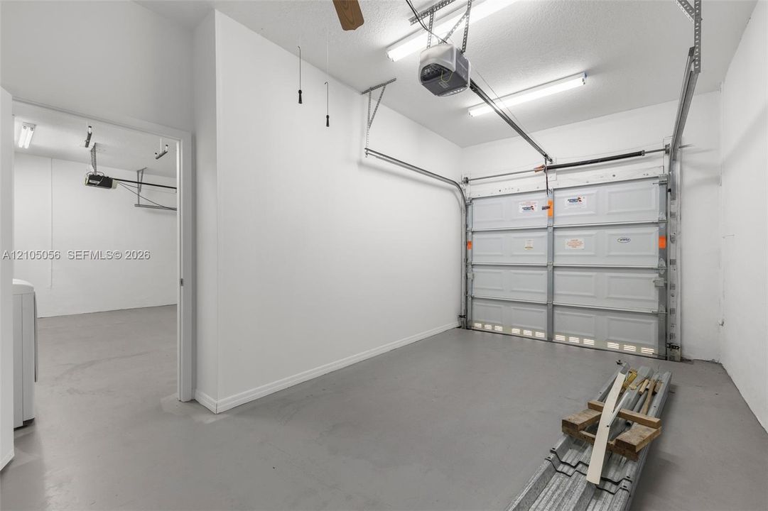 Multi-vehicle garage featuring painted concrete flooring, white interior walls, dividing wall can easily be removed