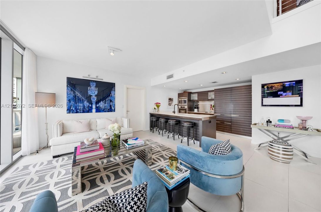 Main-level living room with sofa seating and a direct connection to the kitchen breakfast bar.