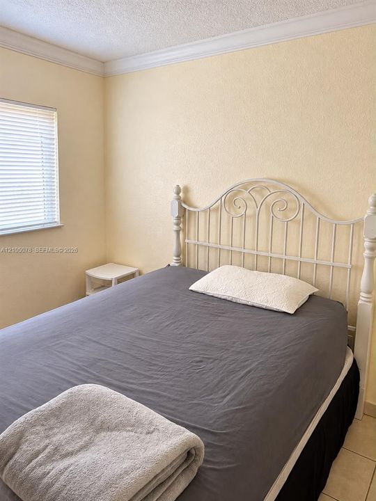 Room featuring crown molding, neutral wall finishes, and tile flooring