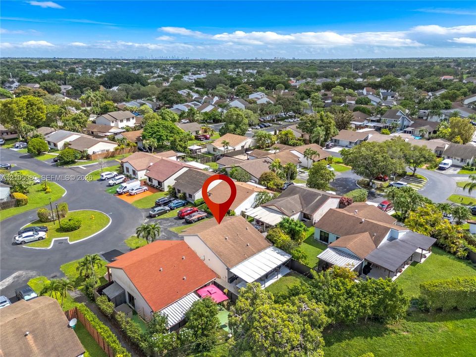 Aerial perspective of property featuring a neutral-toned exterior, concrete roof tiles, and an expansive covered rear patio