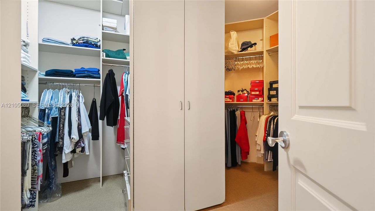 Walk-in closet featuring floor-to-ceiling built-in shelving, integrated garment hanging rods, and central double-door cabinetry