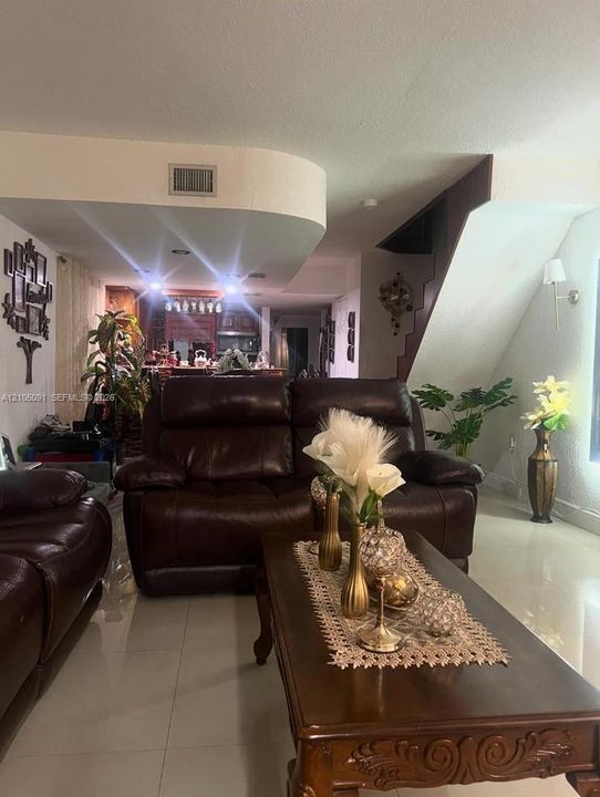 Interior space featuring polished tile flooring, recessed ceiling lighting, and a wall-mounted sconce