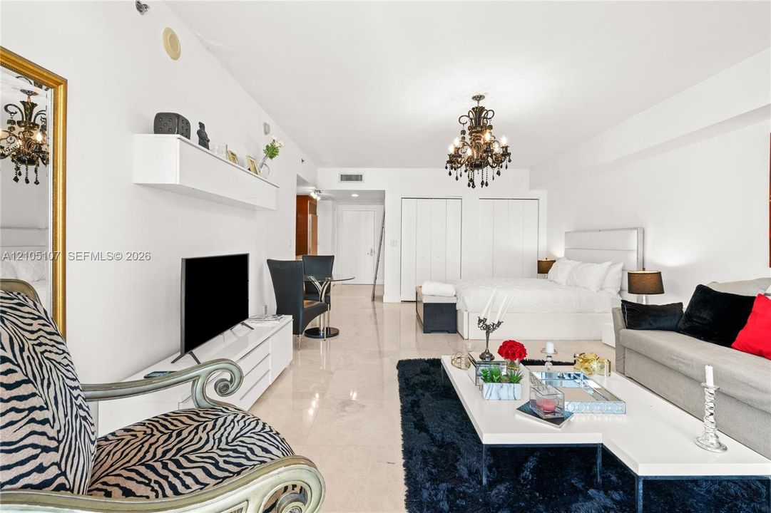 Light-toned flooring, white walls, and a decorative chandelier