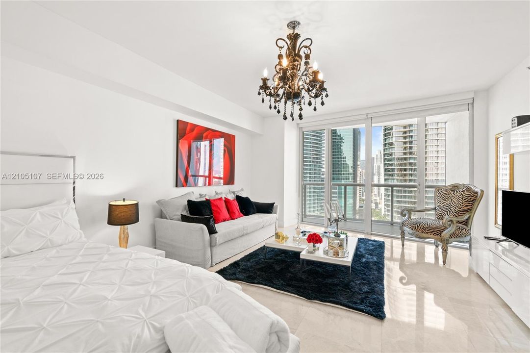 Polished tile flooring throughout, featuring a decorative chandelier and full-height glass doors