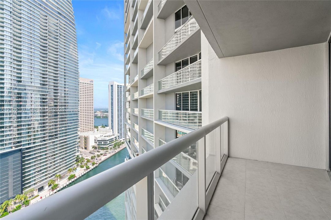 Balcony featuring tile flooring and a glass railing