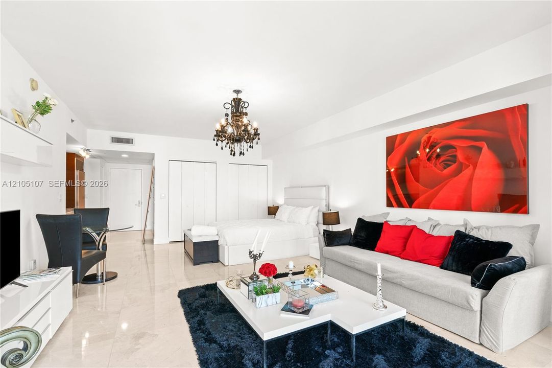 Polished tile flooring, built-in wall shelving, a decorative chandelier, and a white paneled door