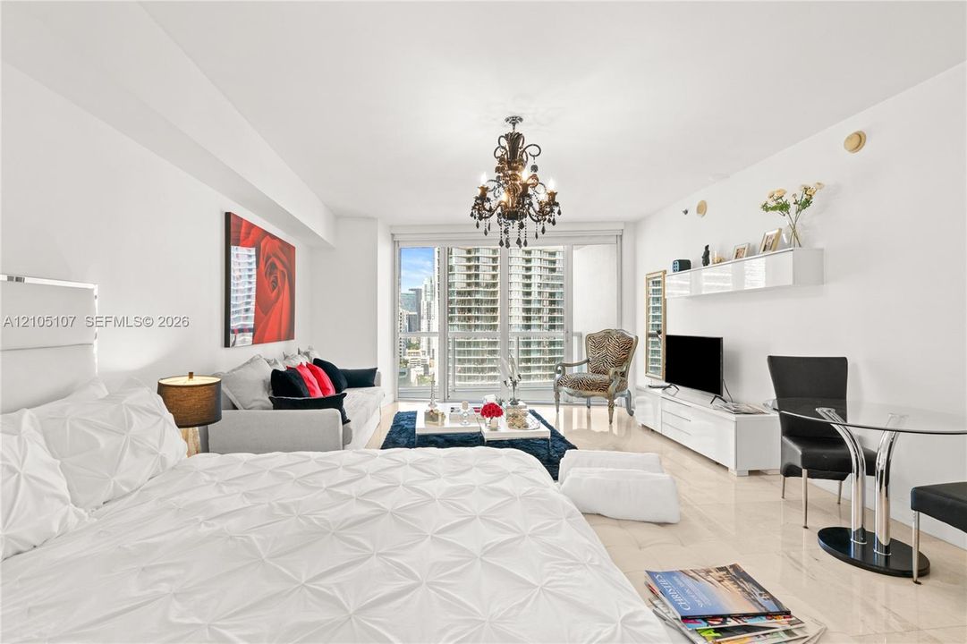 Recessed lighting, chandelier, light-toned flooring, full-height window, white walls