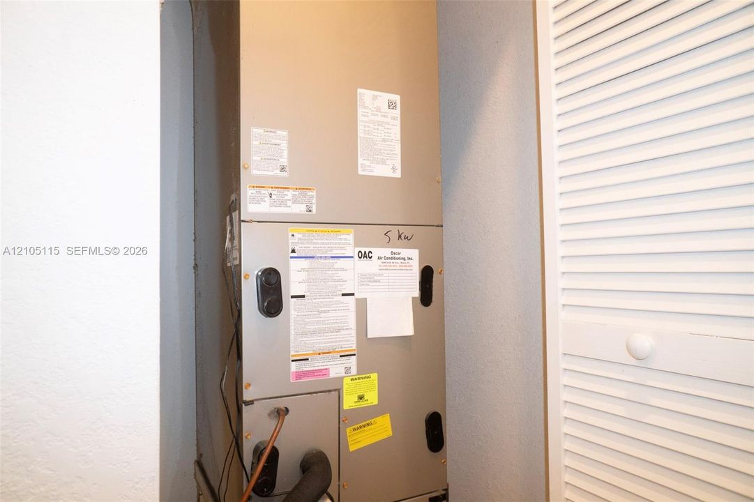 High-efficiency HVAC air handler unit featuring a metallic finish and louvered closet door access