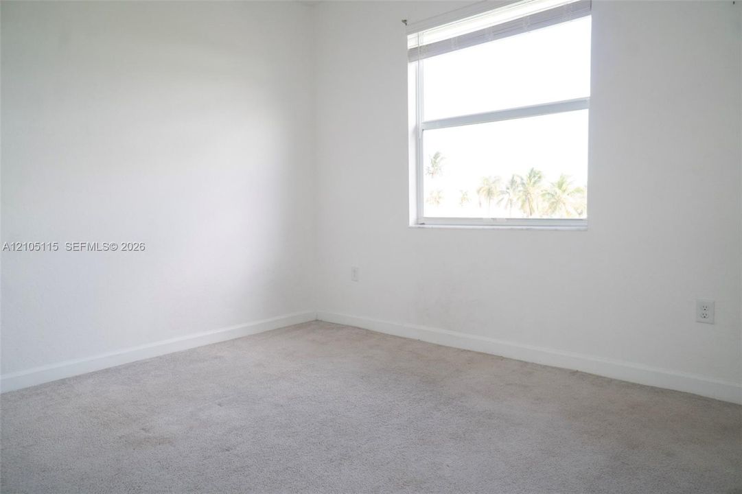 Neutral-toned carpeting, white wall finishes, and a single-hung window with blinds