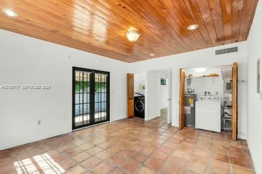 Interior space featuring terra cotta tile flooring, vaulted wood-plank ceiling, recessed lighting, and dual French doors with black frames