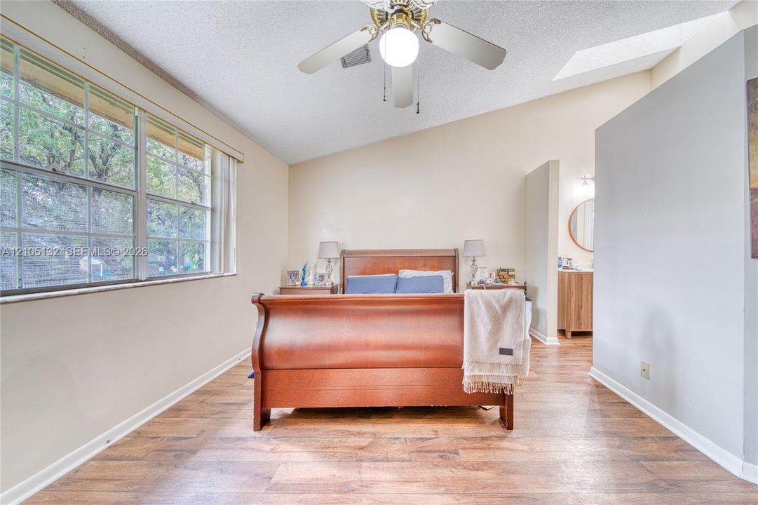 Vaulted ceiling with skylight and ceiling fan