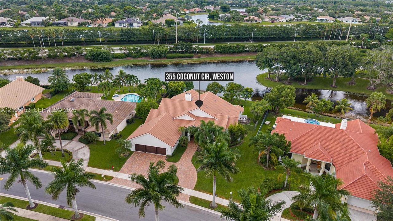 Tile roof residence with a paver driveway, an integrated garage, and a swimming pool