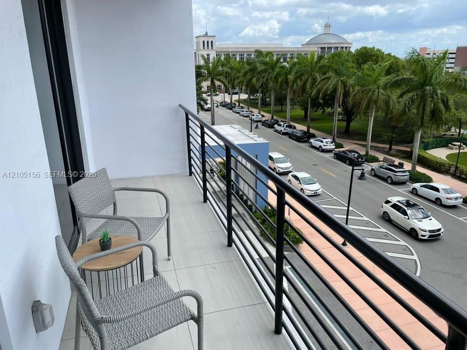 Private balcony featuring large-format tile flooring and a black metal railing
