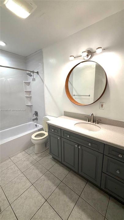 Vanity with grey cabinetry, white countertop, and integrated sink