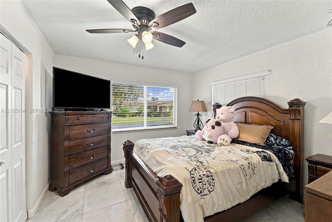 Large format tile flooring, ceiling fan with integrated lighting, and multi-panel interior door