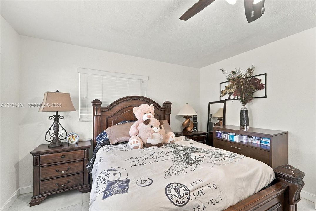 Neutral-toned room featuring a ceiling fan with integrated lighting and horizontal slat window blinds