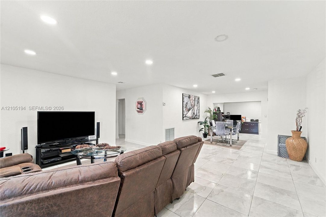 Open-concept interior featuring high-gloss large format tile flooring and recessed lighting