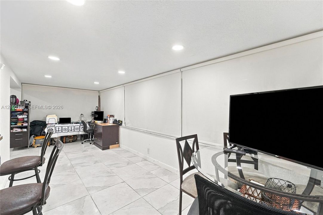 Large-format tile flooring, recessed ceiling lighting, and expansive window treatments