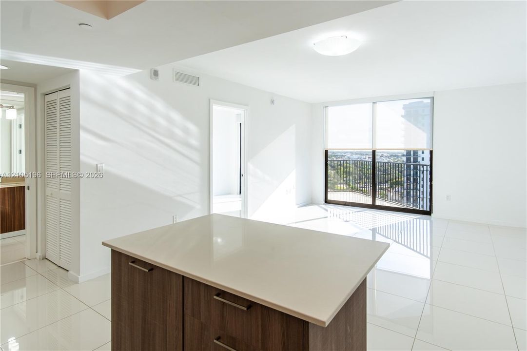 Contemporary kitchen island with a light-toned countertop and wood-finish cabinetry