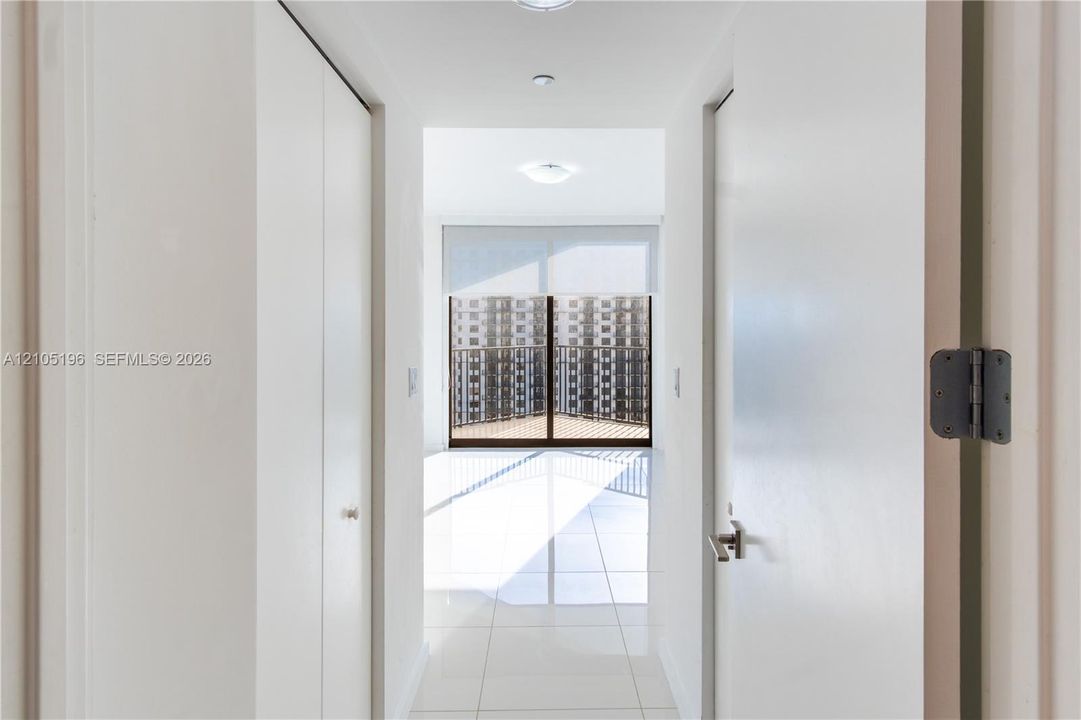 White tile flooring, recessed lighting, and a private balcony with protective railing