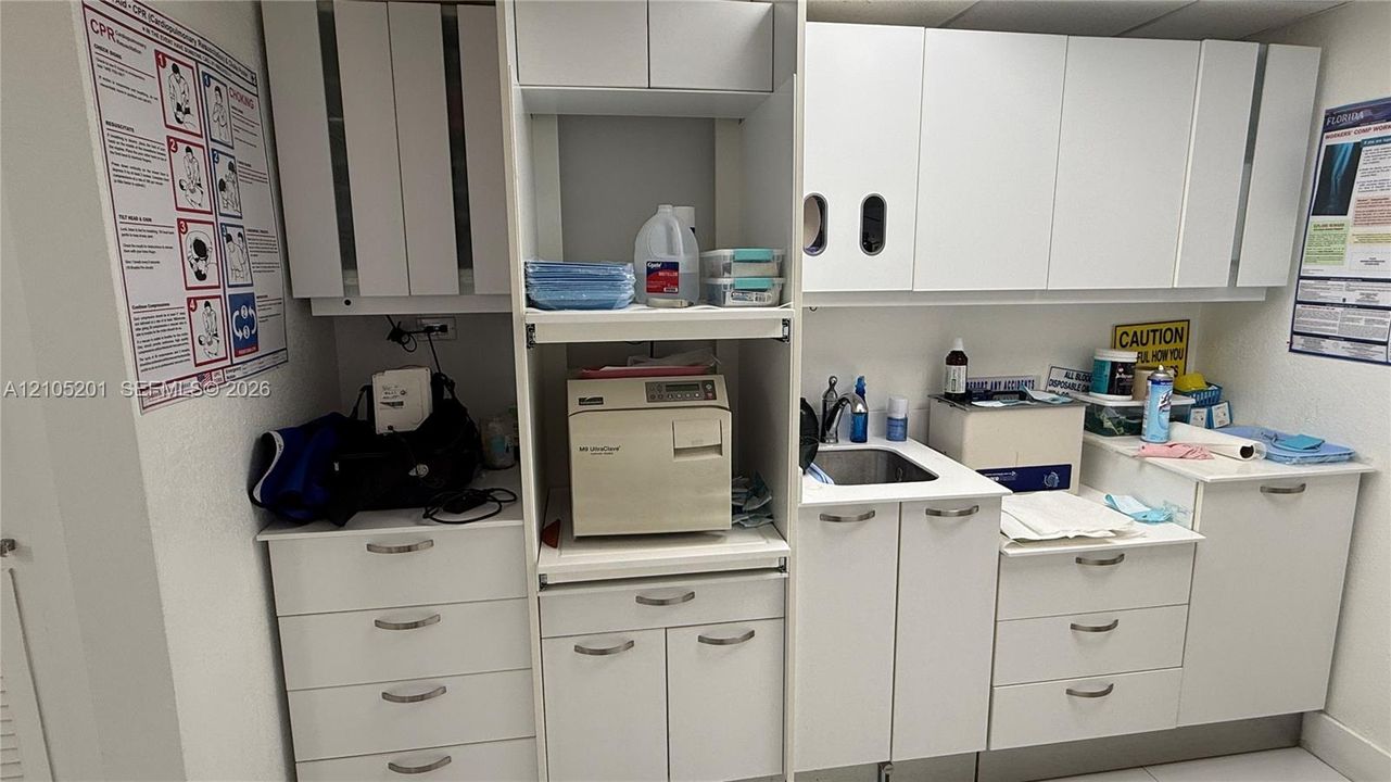 Extensive built-in white cabinetry, integrated sink, and white countertops