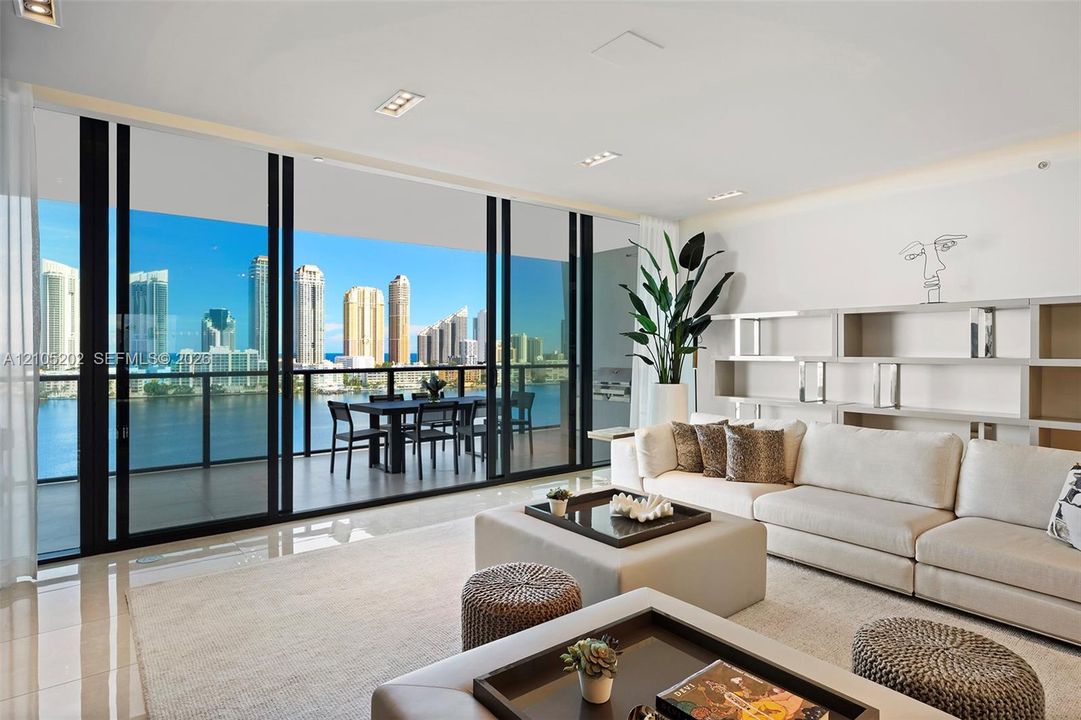 Floor-to-ceiling glass sliding doors, covered balcony with metal railing, polished tile flooring, and integrated built-in shelving