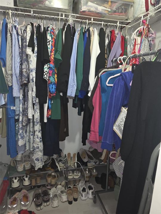 Walk-in closet featuring tiered wire shelving and integrated hanging rods