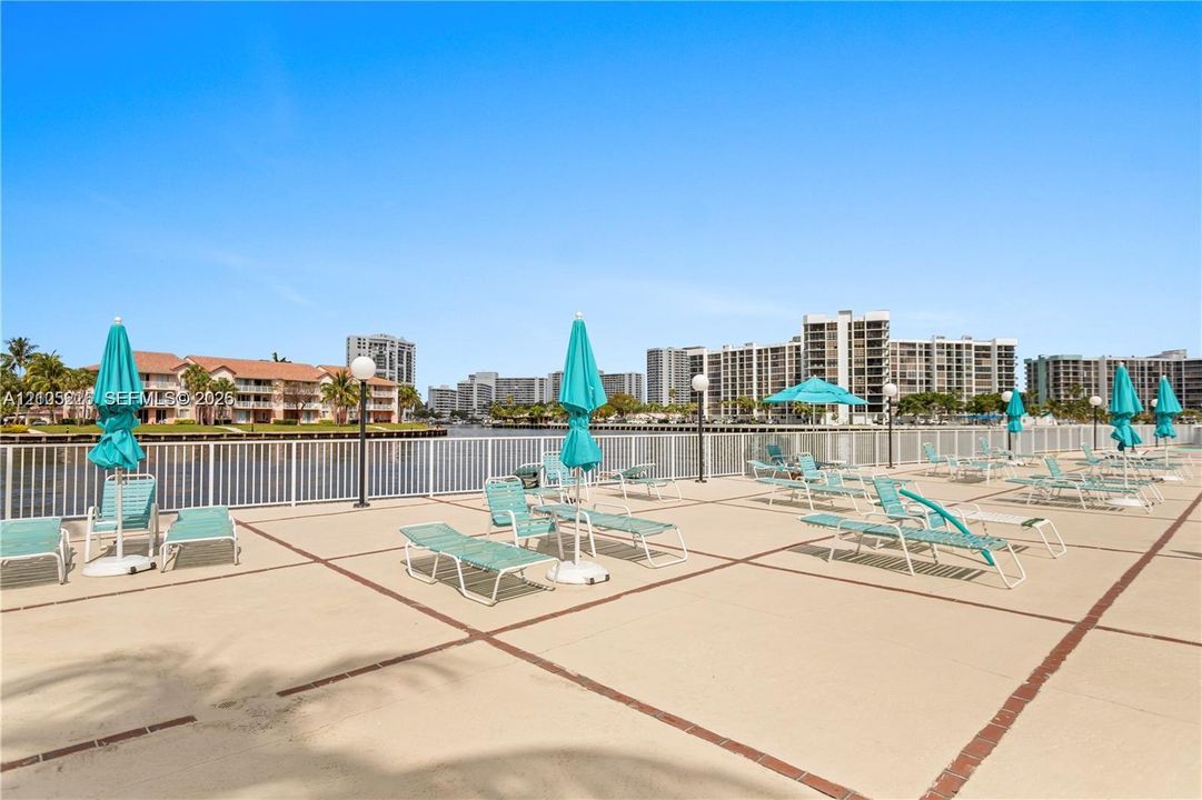 Concrete deck with tile grid detailing, white perimeter railing, and waterfront orientation