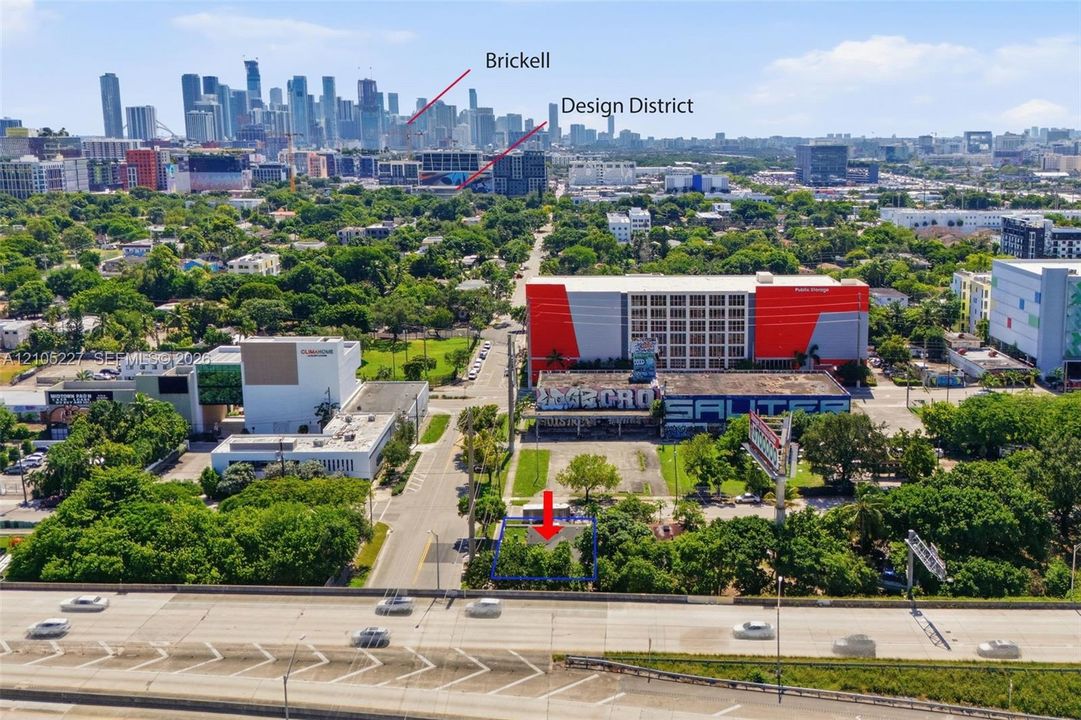 Aerial perspective of a vacant lot featuring mature trees and street-level access