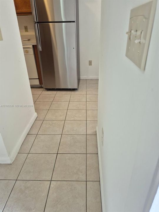 Ceramic tile flooring, stainless steel refrigerator, and built-in dishwasher