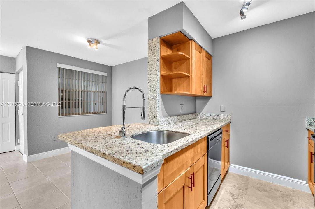 Kitchen island featuring a stainless steel sink with a gooseneck faucet