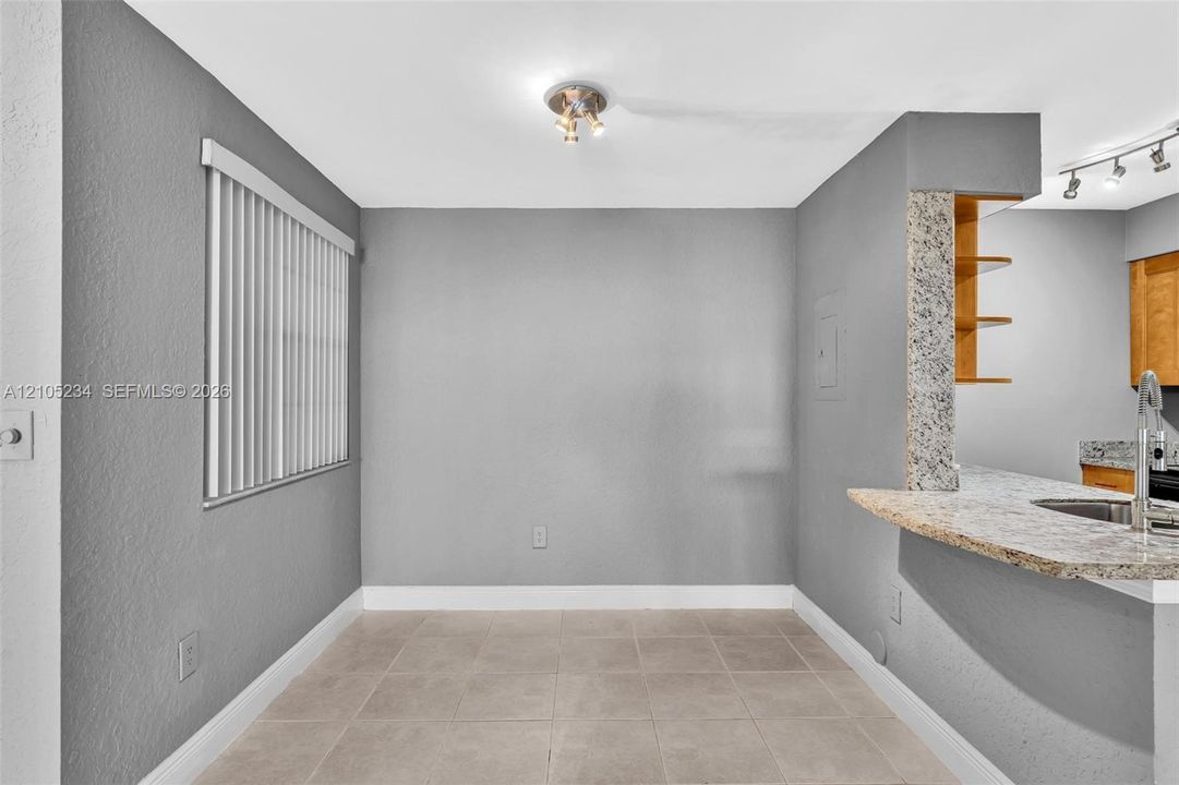 Recessed lighting, tile flooring, window with blinds, granite-style countertop, and built-in shelving