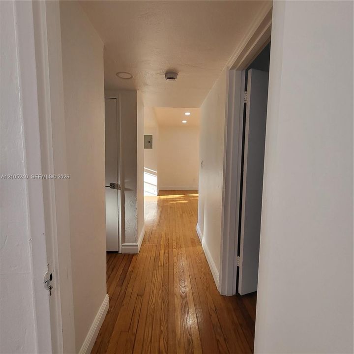 Hardwood flooring throughout, recessed lighting, and crisp white walls