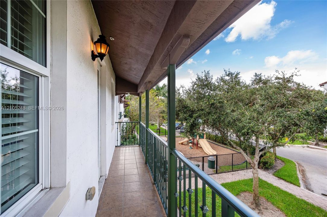 Balcony featuring tile flooring, a decorative wall sconce, and a wood-paneled ceiling