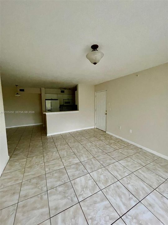 Expansive floorplan featuring light-toned tile flooring, neutral wall tones, and a semi-flush mount ceiling fixture
