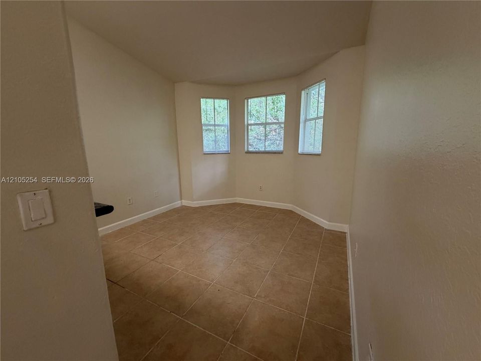 Bay window with three individual windows, tile flooring, and light neutral wall paint