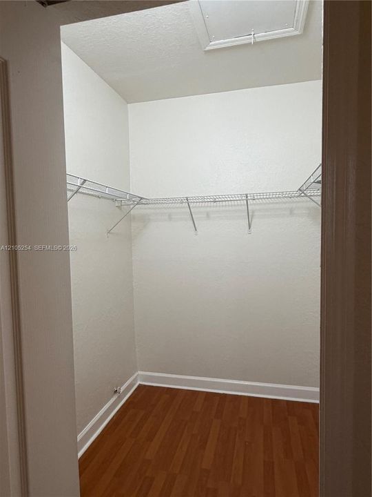 Recessed closet with wood-finish flooring, white walls, and wire shelving system