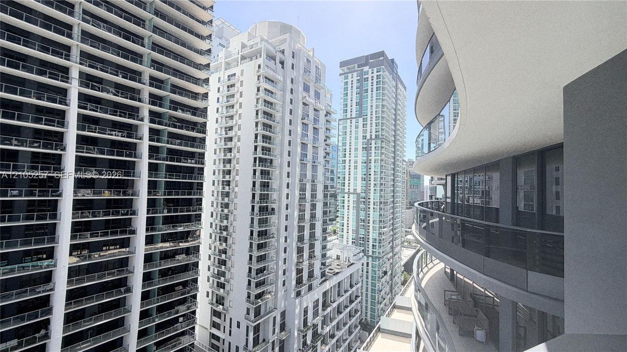 Curved balcony featuring glass railings and expansive floor-to-ceiling windows