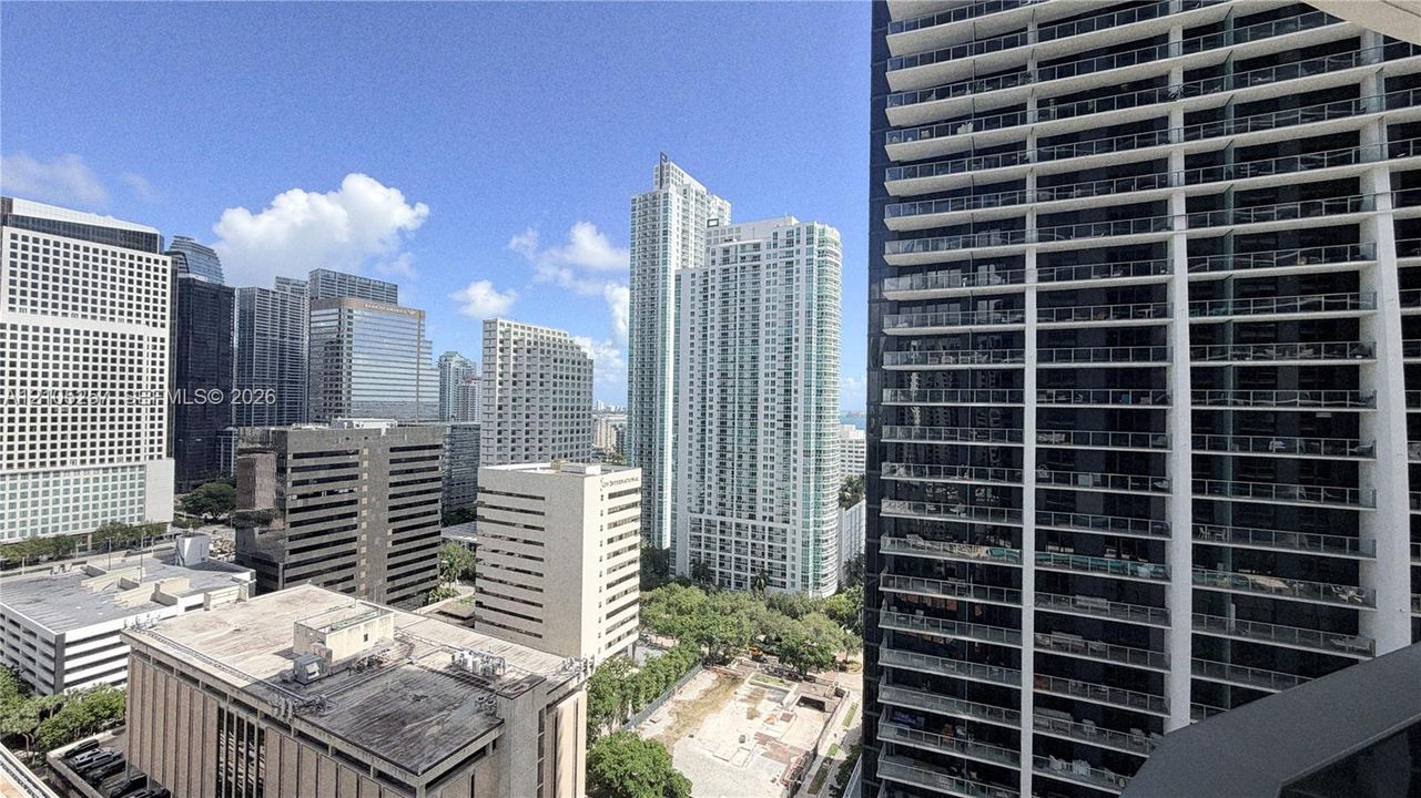 High-rise balcony featuring a glass-panel railing and extensive cityscape surroundings
