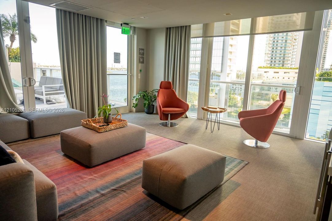 Floor-to-ceiling windows with roller shades and drapery